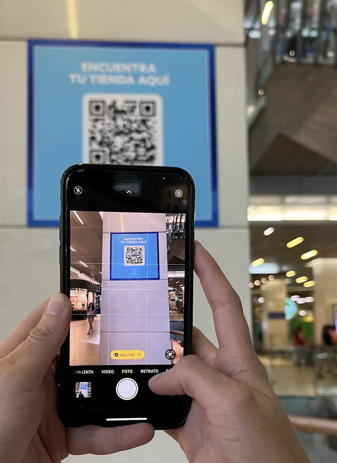 A woman scans a qr code on her phone in a mall